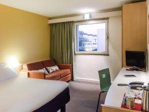 a hotel room with a bed and a couch at Hotel ibis Porto Sao Joao in Porto +78 photos