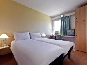 a large white bed in a hotel room at Hotel ibis Guimaraes in Guimarães