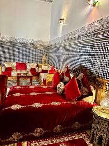 a bedroom with a large bed with red pillows at Riad Damia Suite & Spa in Fez