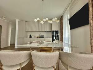 a dining room with a glass table and chairs at Keri Luxury Apartments in Oradea
