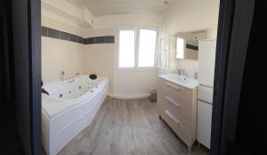 a bathroom with a large tub and two sinks at Villa-appartement de 70 m2 à Agde in Agde