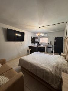 a bedroom with a bed and a couch and a kitchen at Estancias Nava #6 in San Antonio