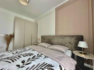a bedroom with a bed with a black and white blanket at Keri Luxury Apartments in Oradea