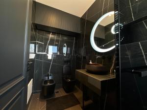 une salle de bain avec un lavabo, des toilettes et un miroir dans l'établissement Theemeraldsuiteapartament, à Tirana 18 autres photos
