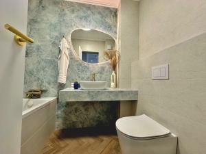 a bathroom with a sink and a toilet and a mirror at Keri Luxury Apartments in Oradea +25 photos