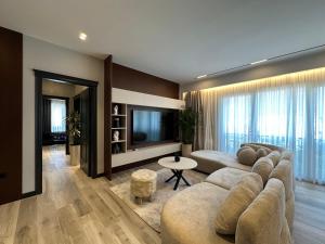 - un salon avec un grand canapé et une télévision dans l'établissement Theemeraldsuiteapartament, à Tirana