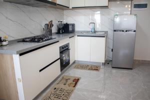 a kitchen with a stove and a refrigerator at Jemmimah jkia homes in Nairobi