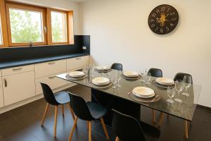 a dining room table with chairs and a clock on the wall at Koblenz Exclusive Residence in Koblenz +7 photos