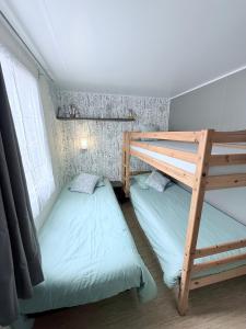 a bedroom with two bunk beds and a ladder at Mobil home dans camping familial piscine in Sainte-Eulalie-en-Born