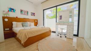 a bedroom with a bed and a dresser and a window at Villa AMAYA Grand Luxe face a la mer in Douar el Hafey