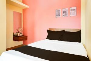 une chambre avec un lit blanc avec des murs rouges dans l'établissement Hotel O Samruddhi Executive Lodge, à Pune