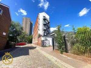 a building on a brick road next to a fence at Stylist Ground-Floor Studio Near City Centre in Portsmouth