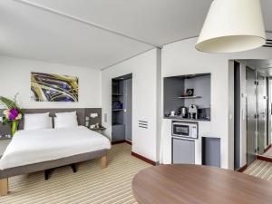 a bedroom with a bed and a table at Novotel Suites Paris Montreuil Vincennes in Paris