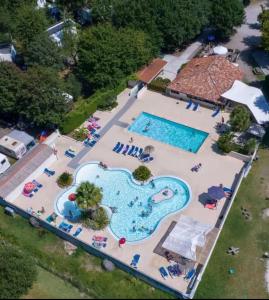 an aerial view of a swimming pool at a resort at Mobil home dans camping familial piscine in Sainte-Eulalie-en-Born