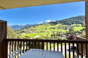 a table on a balcony with a view of a mountain at Les Cimes Blanches in Combloux