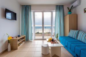 a living room with a blue couch and a large window at Blue Mediterranean Apartments in Sveti Stefan