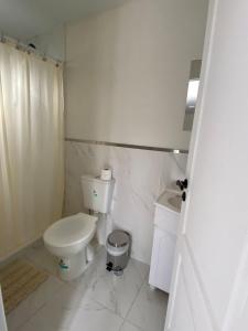 a white bathroom with a toilet and a sink at El Alamo in El Chalten +27 photos