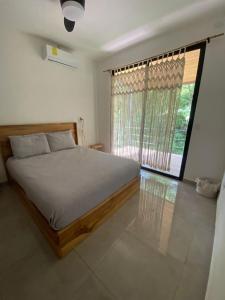 a bedroom with a bed and a large window at Ona Casita 1 in Cuajiniquil