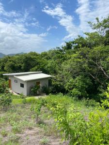 a small white building in the middle of a field at Ona Casita 1 in Cuajiniquil