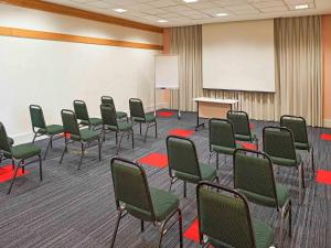 a conference room with green chairs and a whiteboard at Ibis São Carlos in São Carlos