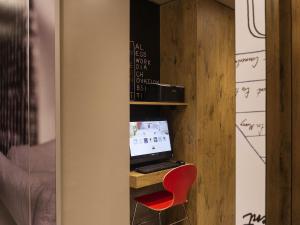 a desk with a computer and a red chair at ibis Paris Vaugirard Porte de Versailles in Paris