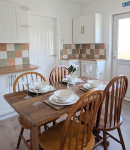 a kitchen with a wooden table with chairs and wine glasses at Kintyre House in Campbeltown