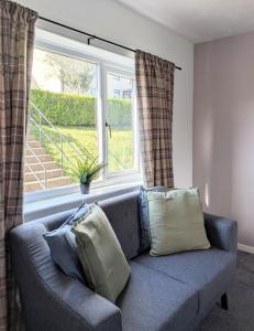a blue couch in a living room with a window at Kintyre House in Campbeltown