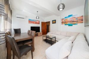 un soggiorno con un divano bianco e un tavolo di Casa Linda a Olhão
