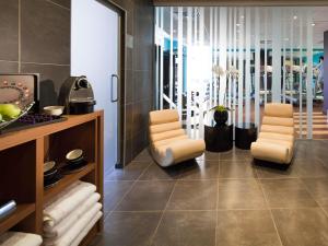 a living room with two chairs and a table at Novotel Leeds Centre in Leeds