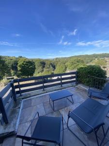 eine Terrasse mit 2 Stühlen und Tischen auf dem Balkon in der Unterkunft Sunset Cottage - 55 South Lane in Holmfirth