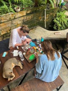 two women sitting at a picnic table with a cat at TheLakeHostel in Hikkaduwa +36 photos