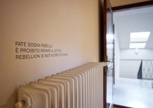 a row of radiators on the wall of a bathroom at Appartamento Rebel House in Pergola