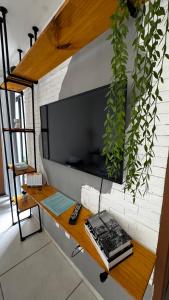 a living room with a tv on a brick wall at Standard Garden 02 in Caruaru