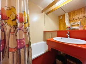 ein Badezimmer mit Waschbecken und Duschvorhang in der Unterkunft Grand studio pour 4, Les Menuires, aux pieds des pistes - FR-1-452-397 in Les Menuires + 11 Fotos
