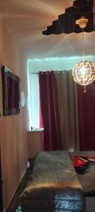 a bedroom with a bed with red curtains and a chandelier at Macarena-AL in Almada +13 photos