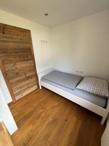 a bedroom with a bed and a wooden door at Ferienwohnung Prutz Tullenweg 17 Oberinntal Tirol in Prutz +20 photos