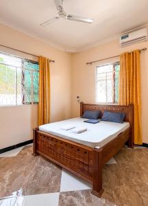 a bedroom with a large bed in a room with windows at Tropicana Villa Nungwi in Kinyasini +29 photos