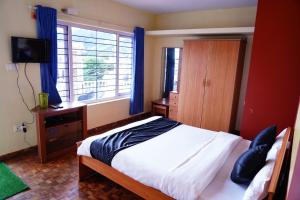 une chambre avec un lit et une fenêtre avec des rideaux bleus dans l'établissement KP Holidays తెలుగు Cottage, à Ooty