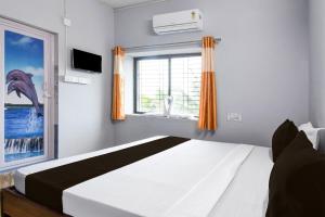 a bedroom with a bed and a window at Hotel O Dream Land in Khandagiri