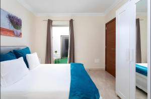El GuinchoにあるApartamento Rolycar 102の白いベッドと鏡のある寝室