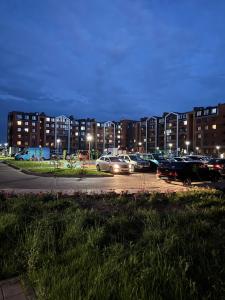 a parking lot with cars parked in front of buildings at Уютная новая квартира в ЖК Береке 2 рядом с Kostanay Plaza in Kostanay +31 photos
