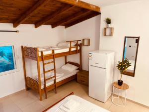 ヒマラにあるPrinnos Rooms Himareの二段ベッド2台、冷蔵庫が備わる客室です。