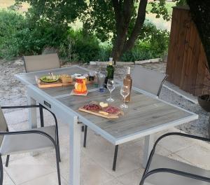 a white table with wine glasses and food on it at La Petite Maison dans la Vigne in Gaujac +5 photos