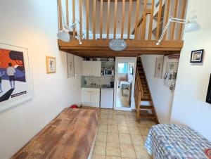 a living room with a staircase and a kitchen at Séjour au calme -Maison 1 chambre pour 4 personnes - Plage à pied in Le Pouliguen +5 photos