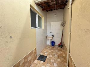 een kleine badkamer met een wastafel en een toilet bij Estadia no Caiçara com Praia a 150m! in Vila Balneária +70 foto's