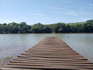 a wooden dock in the middle of a lake at Casa rústica às margens do lago in Maximiliano de Almeida