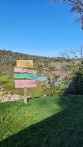 a stack of signs in the grass next to a river at Casa rústica às margens do lago in Maximiliano de Almeida