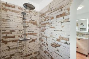 ein Bad mit einer Backsteinwand und einer Dusche in der Unterkunft Finca Pisaverde, a peaceful haven between the sea and Teide in El Pris + 26 Fotos