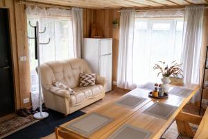 a living room with a couch and a table and a refrigerator at Kodavere puhkemaja 2 in Kodavere