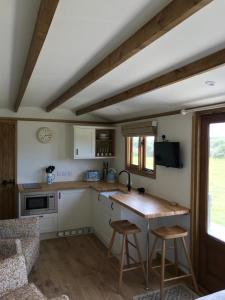 a kitchen with a table and two stools at Ty Beti in Holyhead